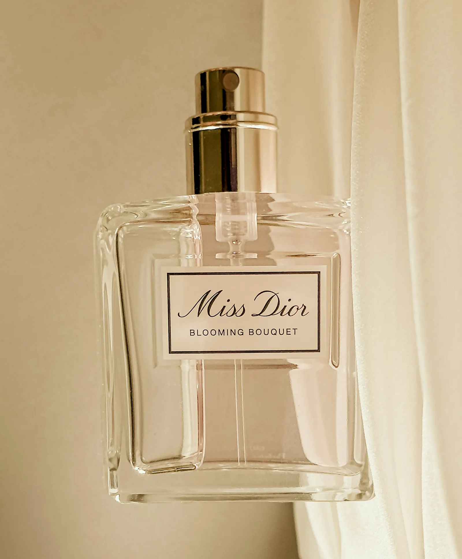 Miss Dior Blooming Bouquet against a sunlit curtain