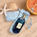 Ard_Al_Zaafaran_Mousuf_Azure_Unisex_EDP_100ml_bottle_and_pouch_on_beach_sand_with_seashells_and_fruit.webp